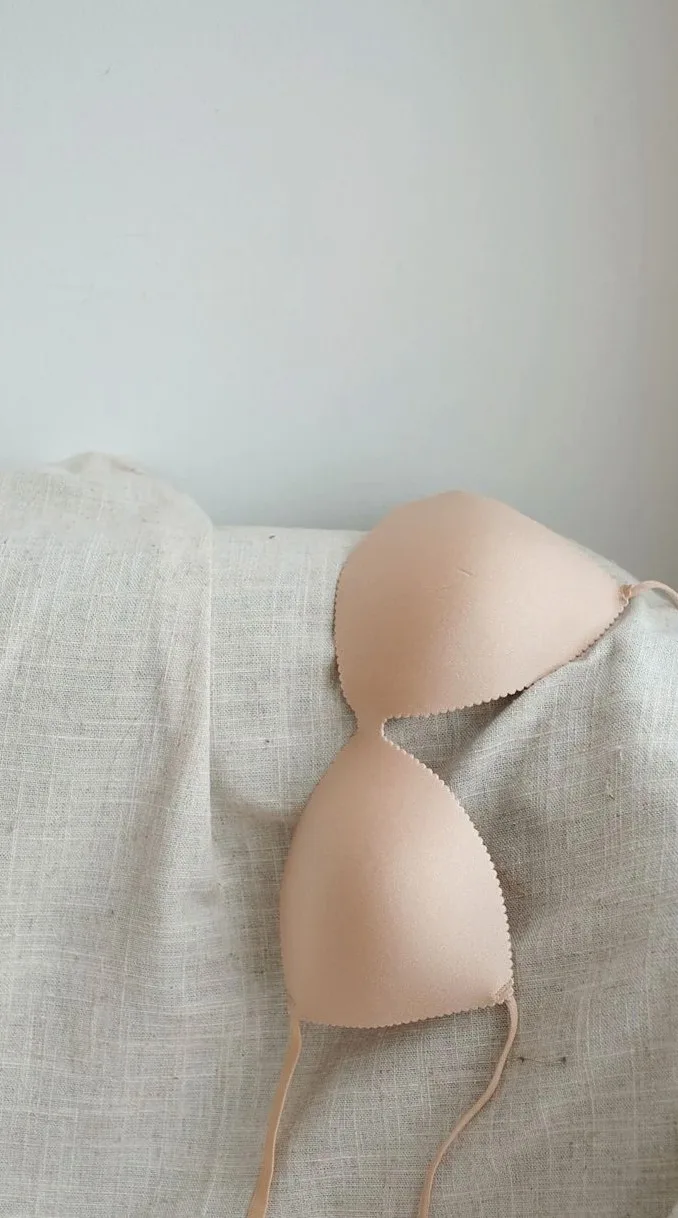 Moulded bra cup resting on a linen cloth