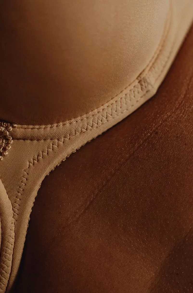 Close-up of the stitched edge of a beige bra cup