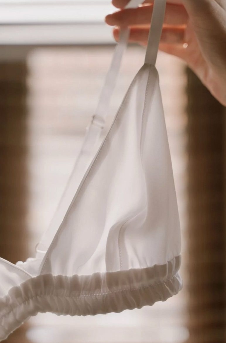 White silk bralette held up by its straps